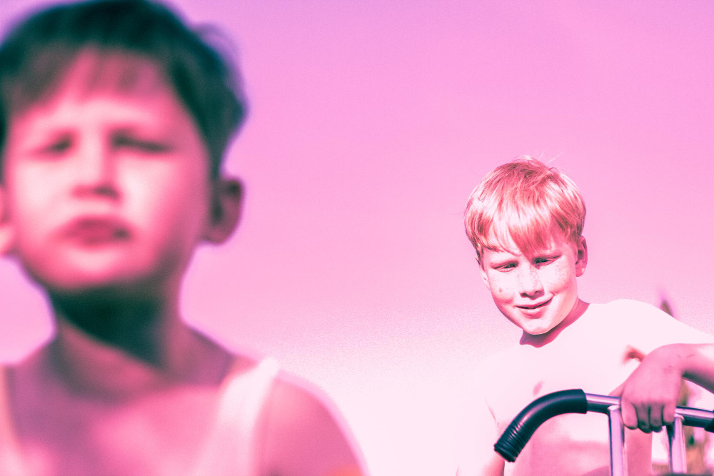 dos niños trans sobre un fondo rosa celebran las infancias trans