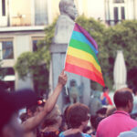 Una persona sostiene una bandera arcoíris que representa los derechos y libertades LGTBIQ+ durante una manifestación